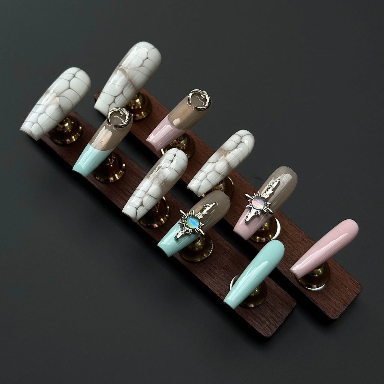 Boho Luxe Press-On Nails bring together a sophisticated mix of textures and colors, combining crocodile-inspired patterns with pastel accents of mint, blush pink, and nude taupe. Adorned with ornate silver charms and gemstone details, these nails capture an elegant bohemian vibe with a touch of luxury.
