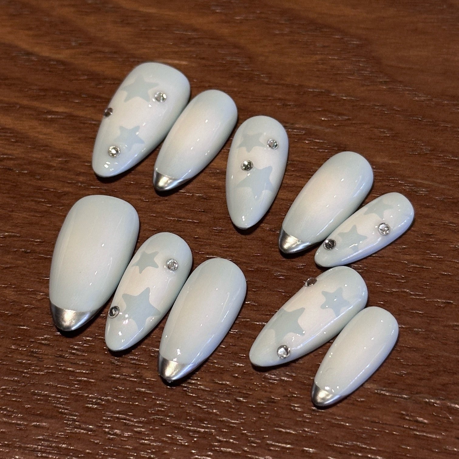 Float on a dreamy sky with Dreamy Skies Press-On Nails, a delicate blend of powder blue gradients, soft star motifs, and metallic silver tips. This whimsical set features a serene ombre effect, transitioning from light blue to pale white, reminiscent of a peaceful, cloudy sky. Adorned with subtle silver accents and ethereal star patterns, Dreamy Skies brings a touch of magic and serenity to your fingertips.