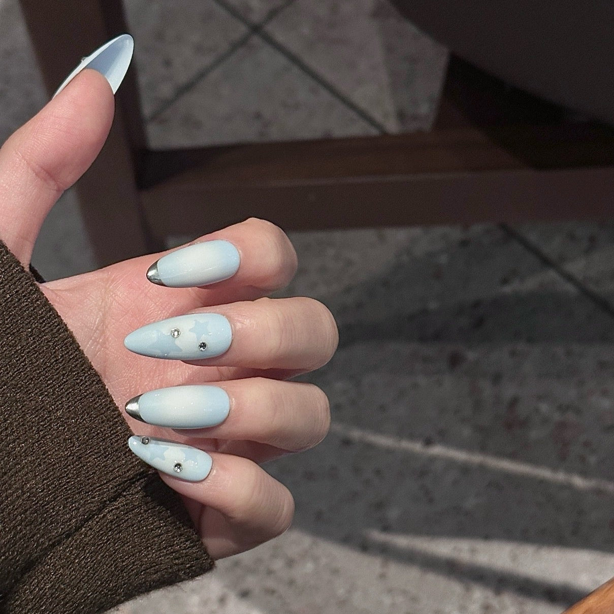 Float on a dreamy sky with Dreamy Skies Press-On Nails, a delicate blend of powder blue gradients, soft star motifs, and metallic silver tips. This whimsical set features a serene ombre effect, transitioning from light blue to pale white, reminiscent of a peaceful, cloudy sky. Adorned with subtle silver accents and ethereal star patterns, Dreamy Skies brings a touch of magic and serenity to your fingertips.