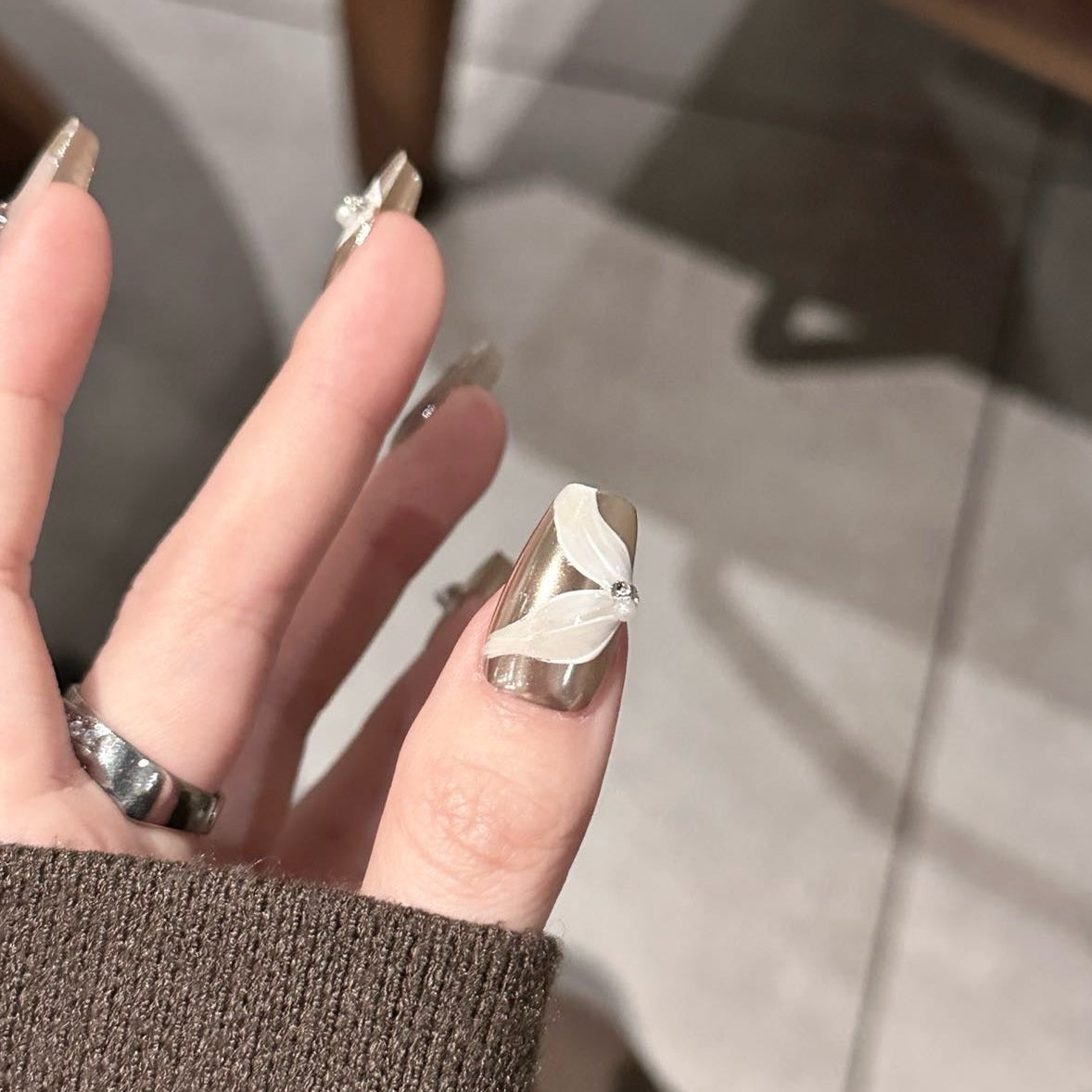 Glamour Noir Press-On Nails bring a sophisticated edge to your look with a chic palette of metallic silver, smoky grey, and bold black polka dots. Designed with elegant 3D ribbon accents and sparkling rhinestones, these nails offer a timeless yet modern flair perfect for evenings out or adding a touch of luxury to any outfit.
