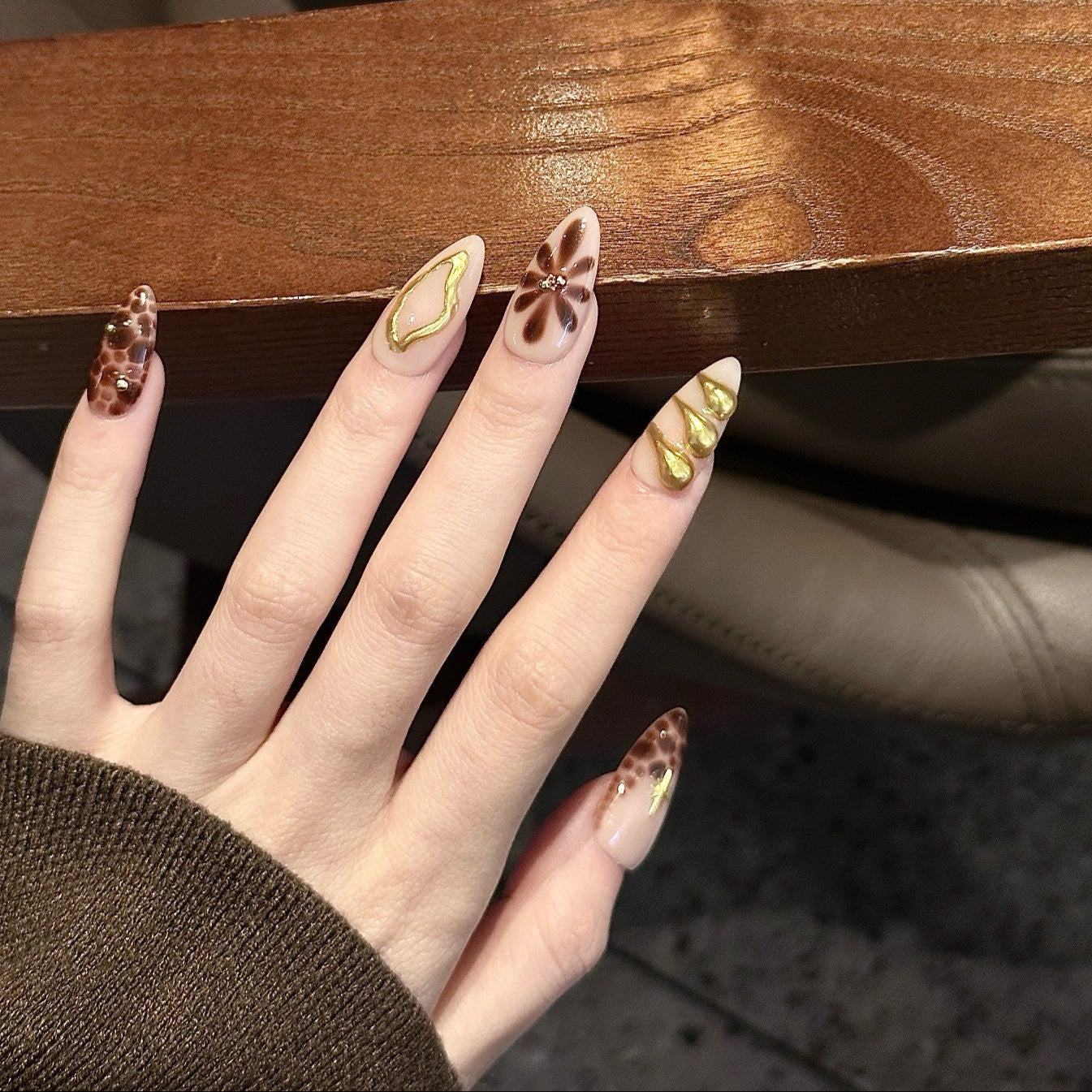 Unleash your wild side with Golden Leopard Press-On Nails, a fierce blend of rich chocolate leopard print, nude-beige base, and luxurious gold accents. This bold set features intricate animal patterns, sculpted gold embellishments, and shimmering star motifs, creating an exotic and glamorous look. The sleek almond shape adds a chic, elongated finish, perfect for those who love a luxurious, fashion-forward aesthetic.