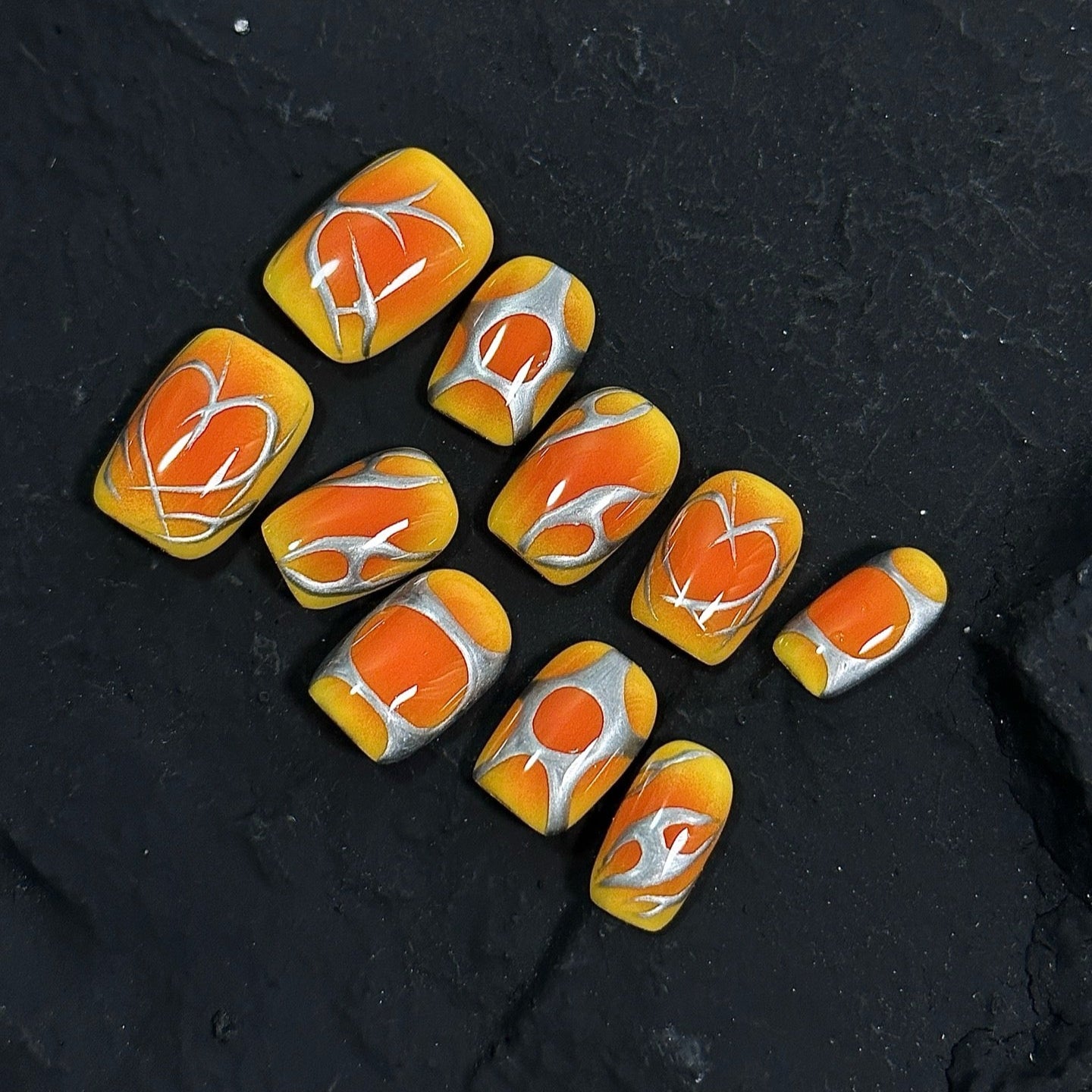 Inferno Swirl Press-On Nails ignite your style with a vibrant blend of fiery orange, golden yellow, and metallic silver. Designed with bold, abstract flame-like patterns, these nails bring an electrifying and dynamic look, perfect for those who love to make a statement.
