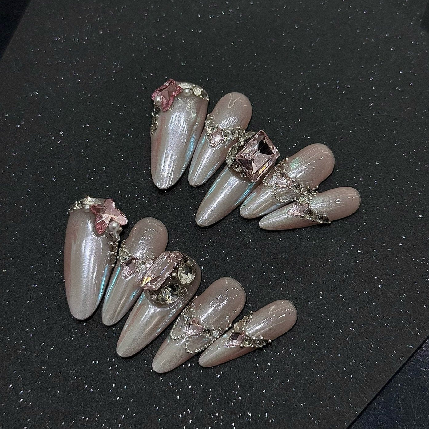 Embrace celestial elegance with Lunar Pearl Press-On Nails, a breathtaking blend of iridescent pearl shimmer, blush pink accents, and luxurious gemstone embellishments. This ethereal set features a luminous, moonlit glow that changes with every angle, adorned with delicate butterfly charms, pearls, and sparkling crystals. The sleek almond shape adds a touch of grace and sophistication, perfect for those who love a dreamy, romantic aesthetic.