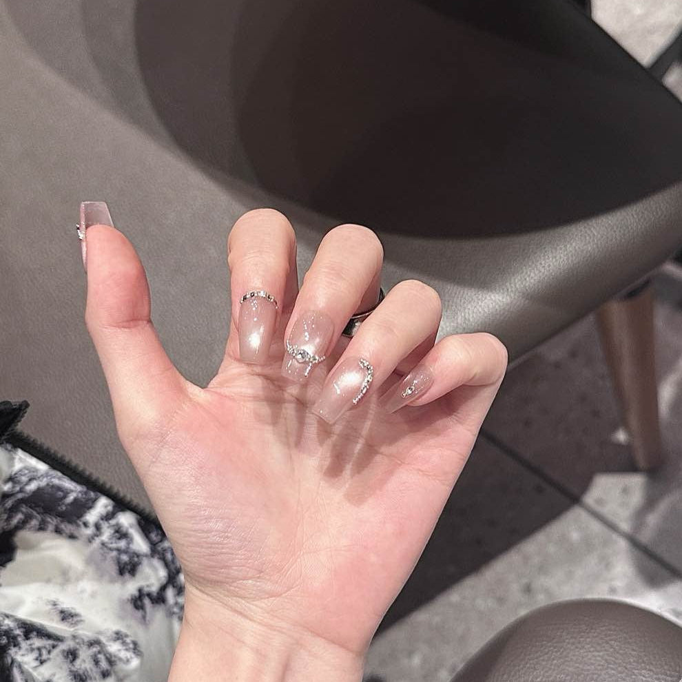 Embrace sophisticated elegance with Luxe Pearl Charm Press-On Nails, featuring a stunning blend of soft pearl pink and delicate silver chain accents adorned with sparkling gemstones. This luxurious set showcases a subtle shimmer that catches the light beautifully, creating an ethereal, radiant look. With a glossy finish and structured short square shape, Luxe Pearl Charm brings a touch of understated glamour and feminine grace to your fingertips.