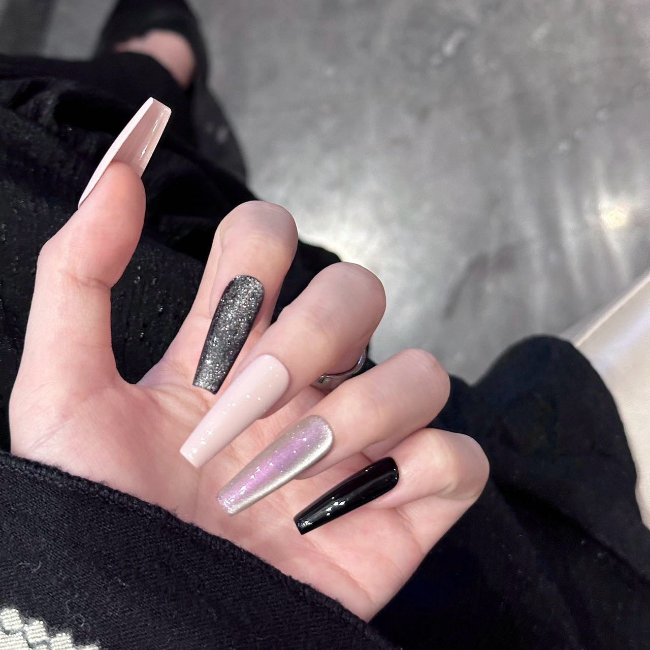 Moonlit Glam Press-On Nails exude sophistication and allure with a striking mix of deep black, soft blush pink, and dazzling metallics. This set is designed for those who love a modern, polished look with a touch of glam.
