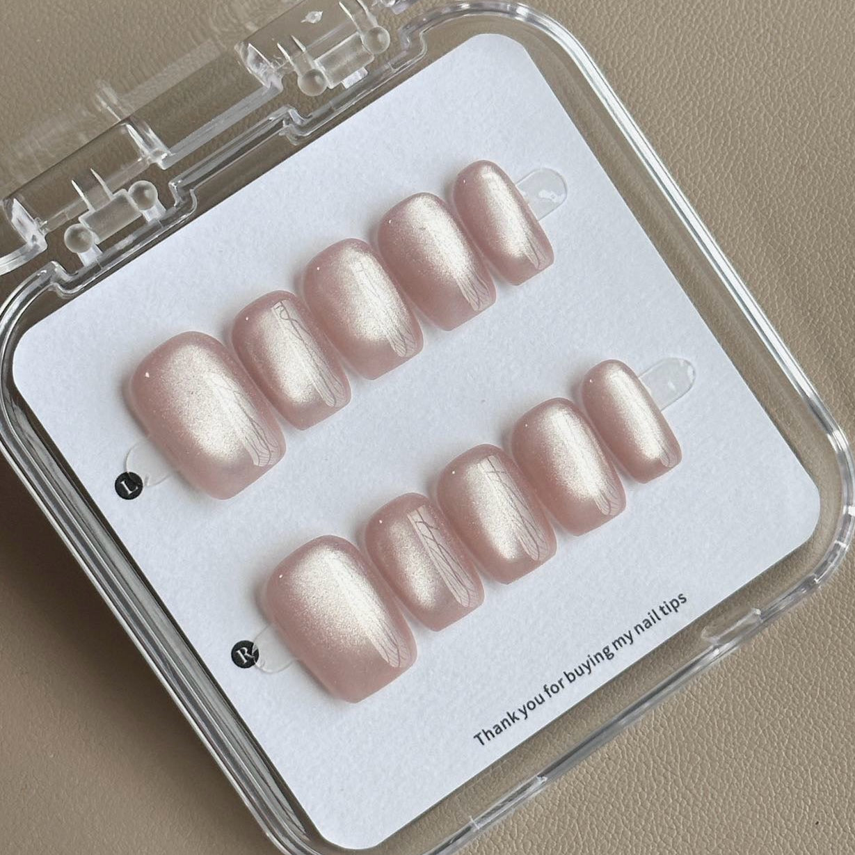 Embrace subtle elegance with Moonlit Pearl Press-On Nails, a stunning blend of soft champagne shimmer and delicate pearlescent glow. This sophisticated set features a graceful short square shape with a glossy, luminous finish that catches the light beautifully, creating an ethereal, moonlit effect. Perfect for those who love a minimalist, refined aesthetic, Moonlit Pearl brings understated luxury to your fingertips.
