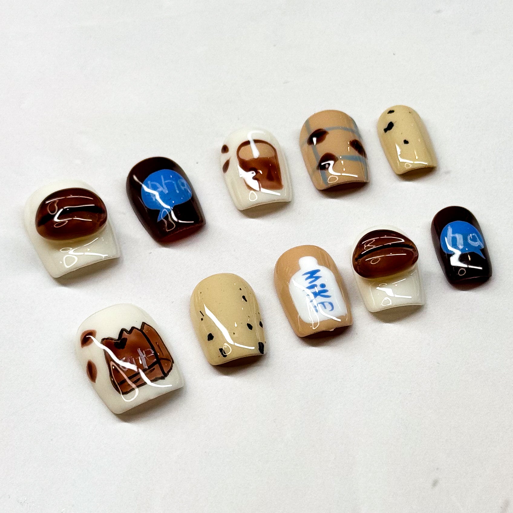 Café Inspired: Includes coffee bean accents, milk carton details, and mocha swirls.
• Cozy Colors: Warm neutrals of cream, caramel, and espresso with pops of blue.
• Short Square Shape: Practical and stylish, perfect for everyday wear.
• Coffee Lover’s Dream: A must-have set for baristas, caffeine fans, or anyone obsessed with café vibes.
• Reusable & Durable: Handmade with premium gel for long-lasting wear.