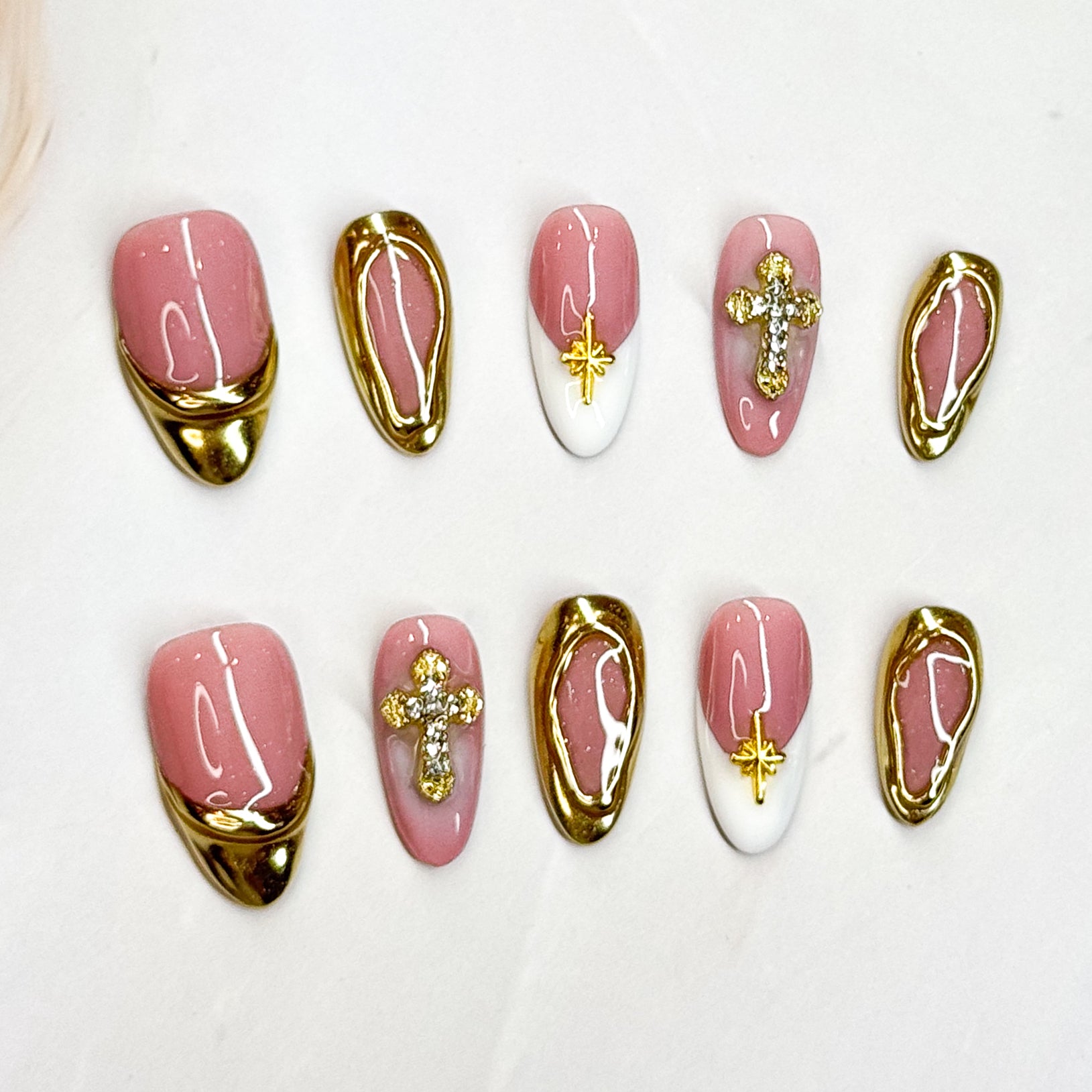 • Luxe Details: Gold chrome edges with sparkling rhinestone crosses and star charms.
• Elegant Almond Shape: A flattering silhouette for all hand shapes.
• Timeless Colors: Soft blush pink with crisp white accents and metallic gold.
• Chic & Versatile: Perfect for weddings, parties, or elevated everyday looks.
• Handmade & Reusable: Crafted with high-quality 3D gel for long-lasting beauty.