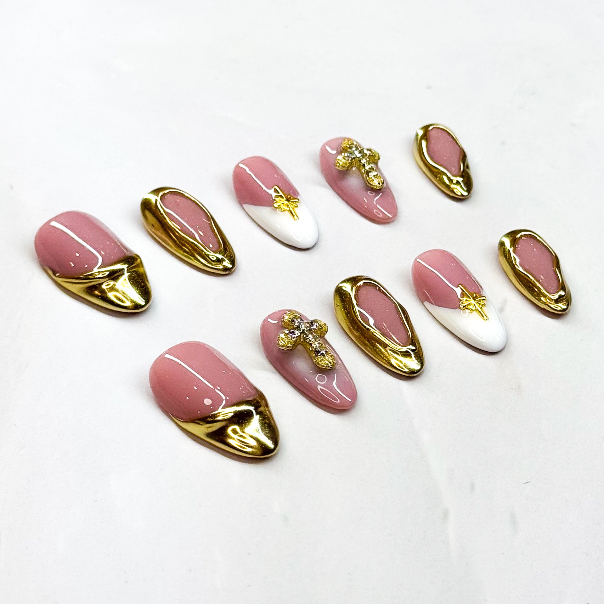 • Luxe Details: Gold chrome edges with sparkling rhinestone crosses and star charms.
• Elegant Almond Shape: A flattering silhouette for all hand shapes.
• Timeless Colors: Soft blush pink with crisp white accents and metallic gold.
• Chic & Versatile: Perfect for weddings, parties, or elevated everyday looks.
• Handmade & Reusable: Crafted with high-quality 3D gel for long-lasting beauty.