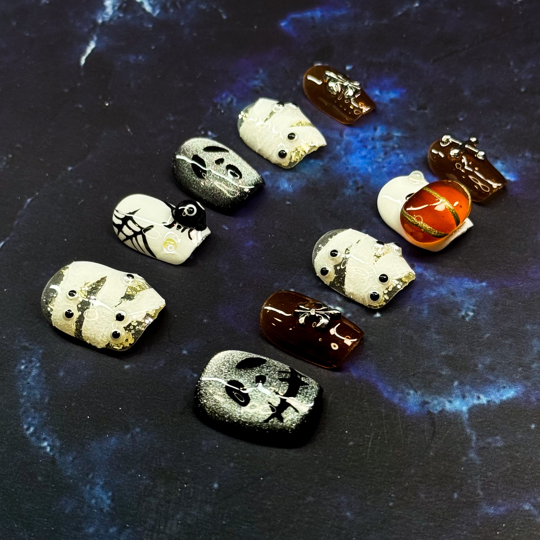 Spooky, playful, and full of Halloween charm — Haunted Night brings the spirit of October to your fingertips with a mix of mummy wraps, ghostly faces, and glowing pumpkins.
Key Features:
• Spooky Cute: Adorable mummy, ghost, and pumpkin designs hand-sculpted in 3D gel.
• Seasonal Shades: Classic Halloween tones of black, white, and orange with a glossy finish.
• Short Square Shape: Comfortable to wear daily while keeping the festive vibe.
• Party Ready: Perfect for trick-or-treating, costume parties, or jus