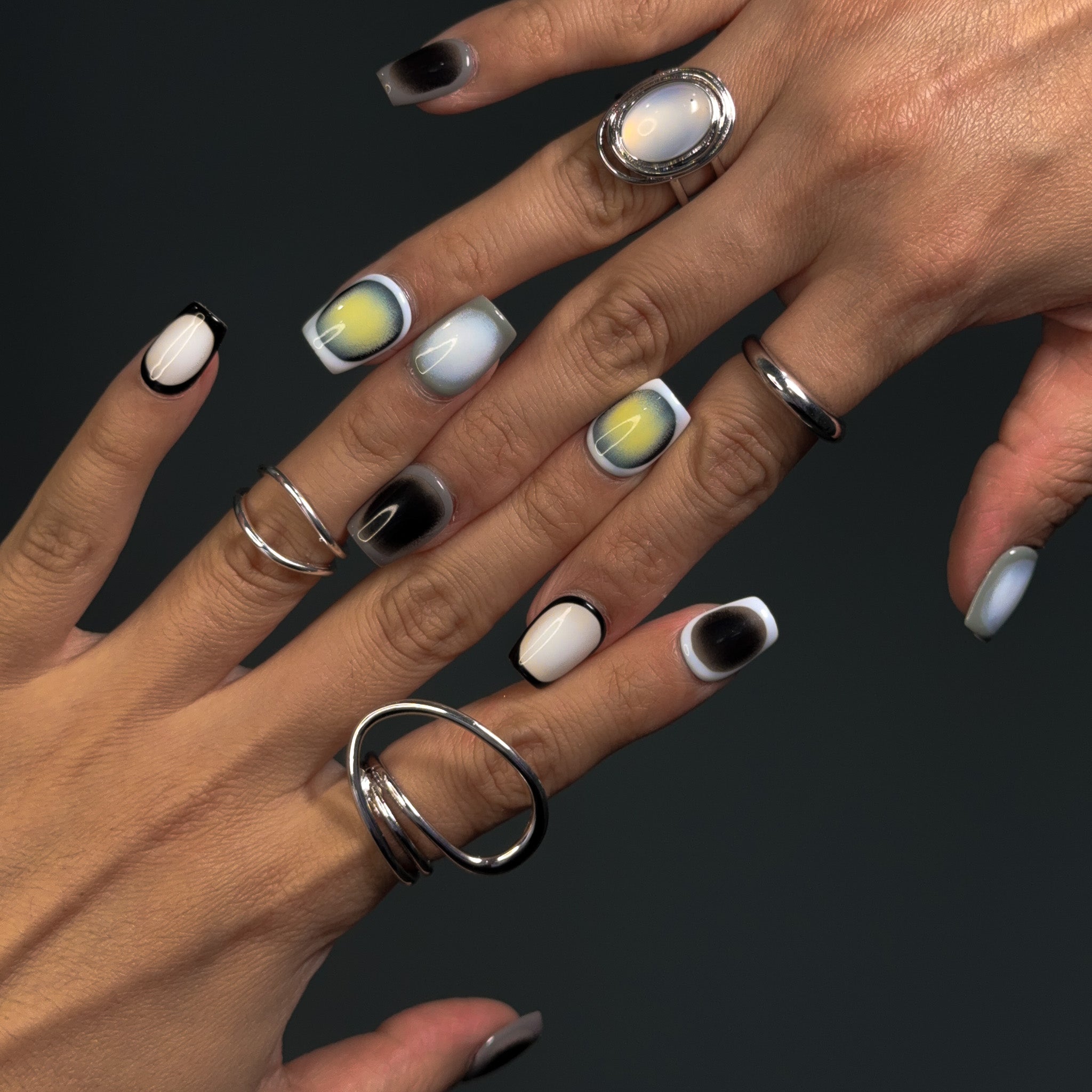 Embrace modern sophistication with Monochrome Mirage Press-On Nails, featuring a short square shape and a minimalist cycle pattern in black, white, and grey. This chic set showcases a subtle cat-eye effect that shifts under different lighting, creating a multidimensional, elegant look. Perfect for those who love a clean, contemporary aesthetic, Monochrome Mirage brings a touch of refined minimalism to your style.