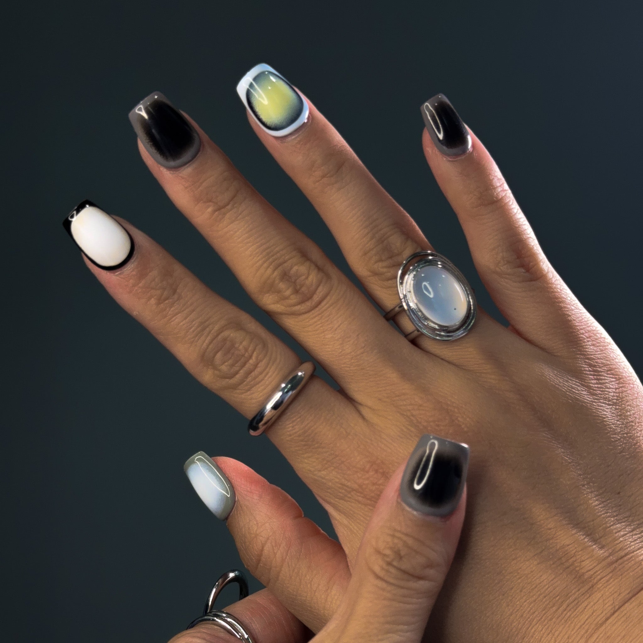 Embrace modern sophistication with Monochrome Mirage Press-On Nails, featuring a short square shape and a minimalist cycle pattern in black, white, and grey. This chic set showcases a subtle cat-eye effect that shifts under different lighting, creating a multidimensional, elegant look. Perfect for those who love a clean, contemporary aesthetic, Monochrome Mirage brings a touch of refined minimalism to your style.