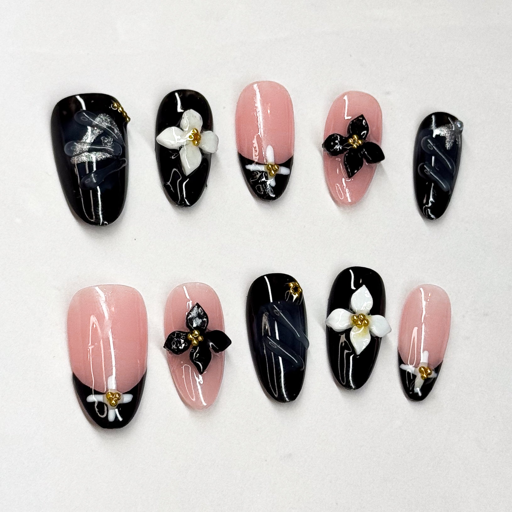 • Black &amp; Pink Contrast: A timeless combo that feels both modern and chic.
• 3D Floral Accents: Handcrafted black and white blossoms with golden centers.
• Elegant Almond Shape: Sleek and elongating for a graceful look.
• Handmade &amp; Reusable: Premium gel artistry built to last.
• Perfect Statement: Ideal for evening events, fashion-forward looks, or anytime you want a striking manicure.
Midnight Bloom is your go-to set for turning soft florals into a bold fashion statement.