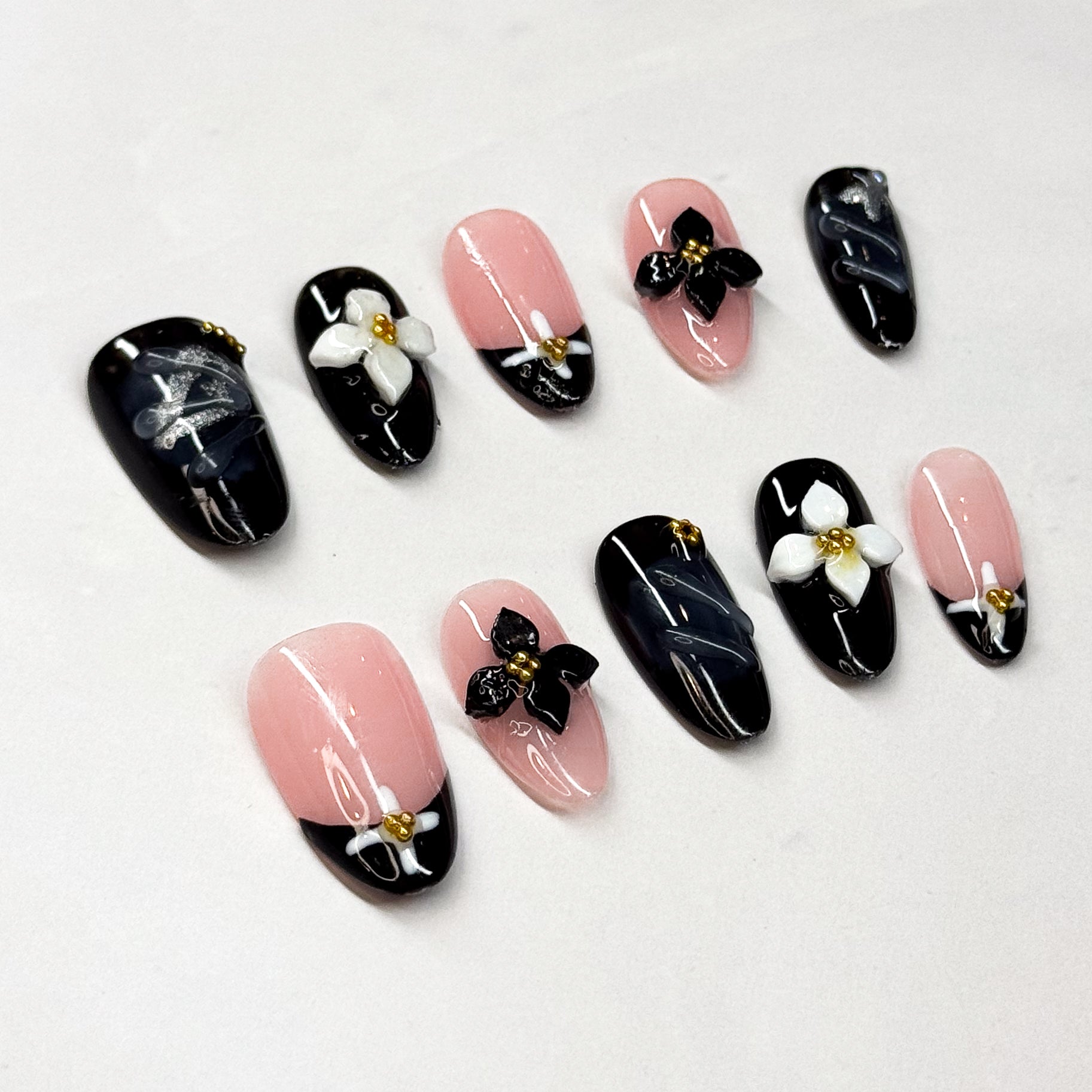 • Black &amp; Pink Contrast: A timeless combo that feels both modern and chic.
• 3D Floral Accents: Handcrafted black and white blossoms with golden centers.
• Elegant Almond Shape: Sleek and elongating for a graceful look.
• Handmade &amp; Reusable: Premium gel artistry built to last.
• Perfect Statement: Ideal for evening events, fashion-forward looks, or anytime you want a striking manicure.
Midnight Bloom is your go-to set for turning soft florals into a bold fashion statement.