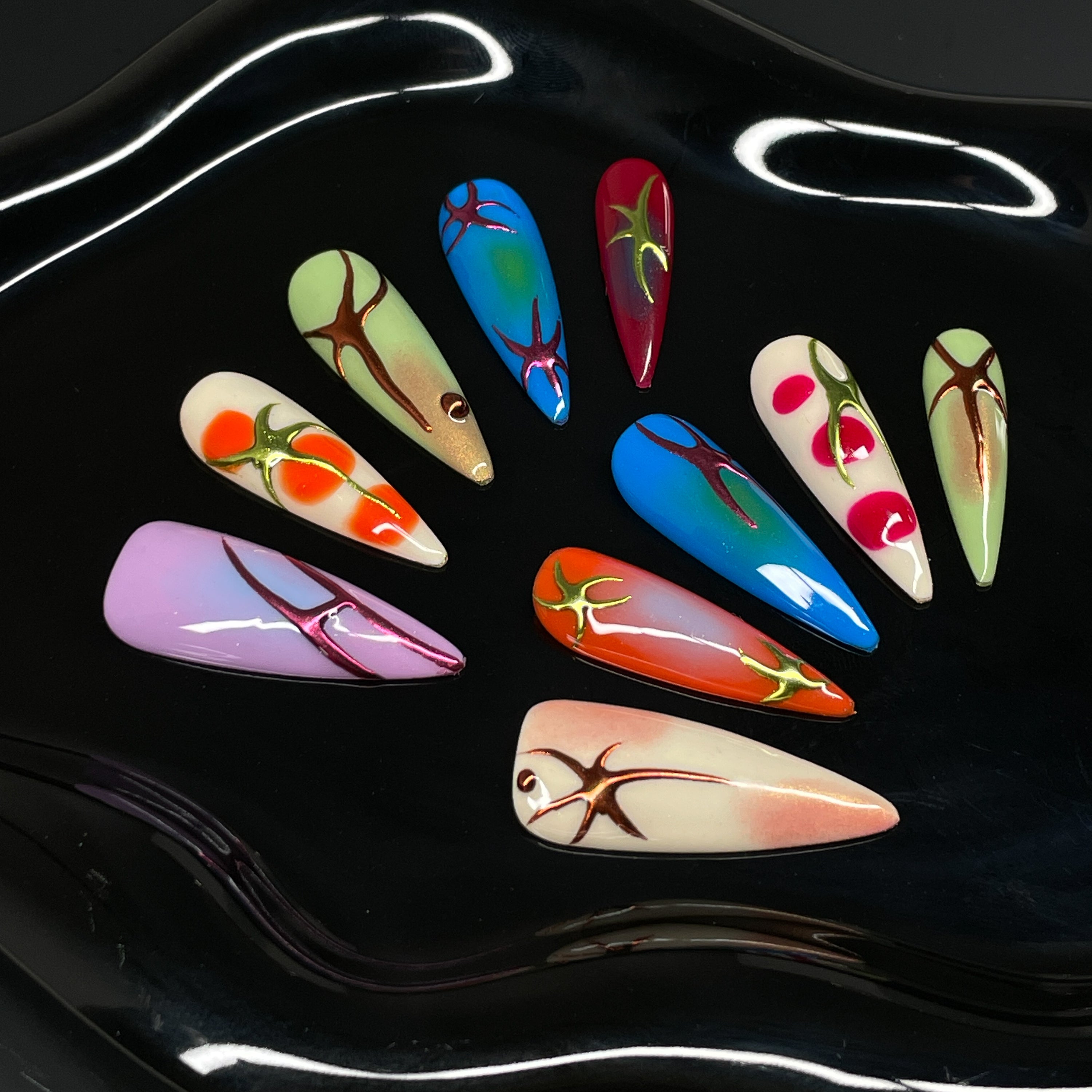 High-Voltage Color: Bright gradients of cherry red, tangerine, electric blue, and acid green pulse across each nail.
• 3D Root-Like Designs: Glossy sculpted accents twist and sprawl like growing vines or energetic flame streaks.
• Gloss & Glow Finish: Smooth, radiant surfaces with just the right amount of sheen to reflect your wild side.
• Unique Per Nail: Each piece is a one-of-a-kind statement—no two roots grow the same way.
• Long Stiletto Shape: Dramatic, elongated points for a high-impact silhouette th