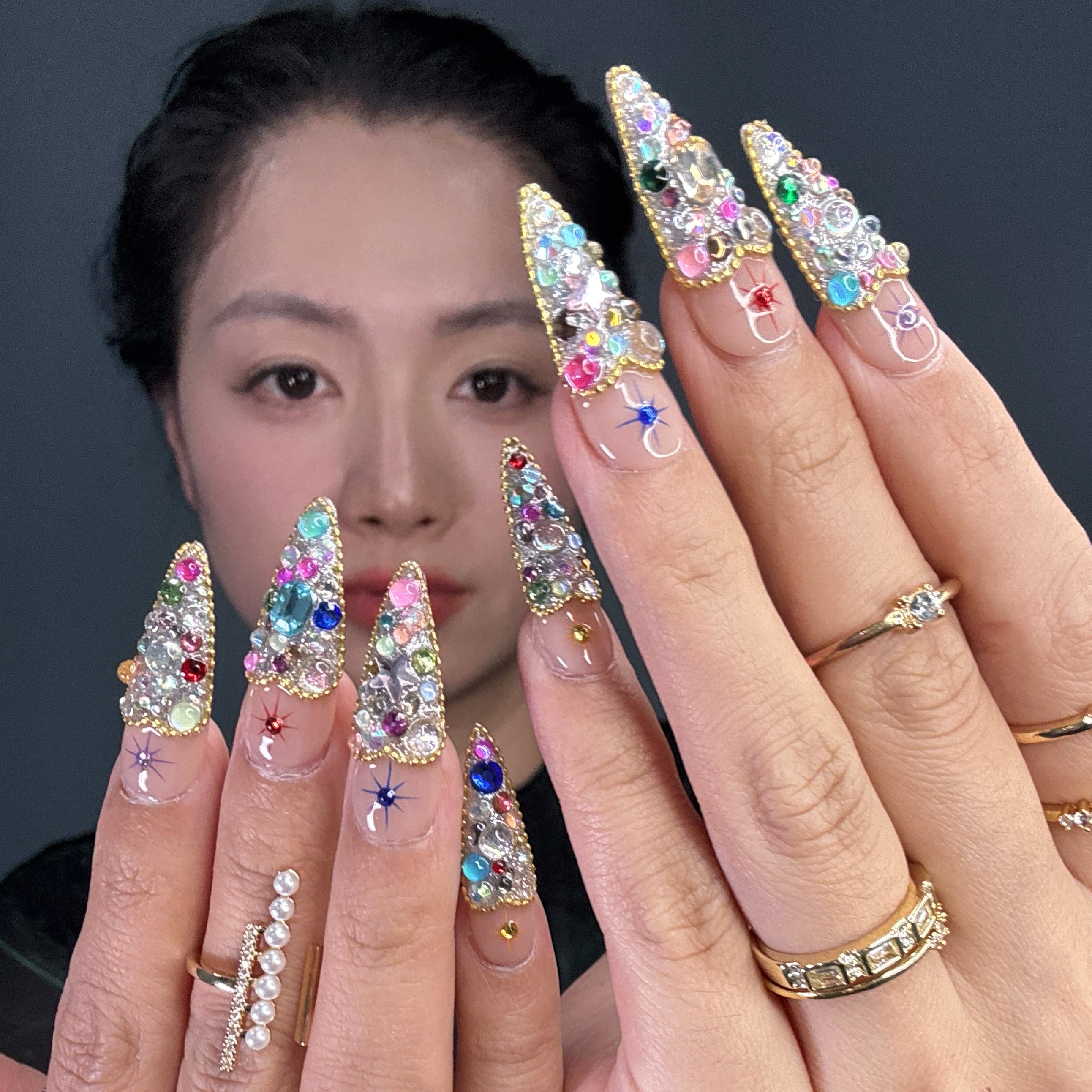 Full Gem Explosion: Packed with multicolored rhinestones, glass crystals, and faceted jewels for instant glam.
• Golden Glitter Base: A bold, sparkling foundation gives each nail the weight of a red carpet moment.
• Starburst Charms: Embedded celestial motifs add a magical pop to every fingertip.
• Luxe Color Palette: Emerald, sapphire, ruby, and amethyst tones blend for a jewel box effect.
• Short Tapered Shape: Compact yet eye-catching—perfect for glam lovers who want comfort and drama.