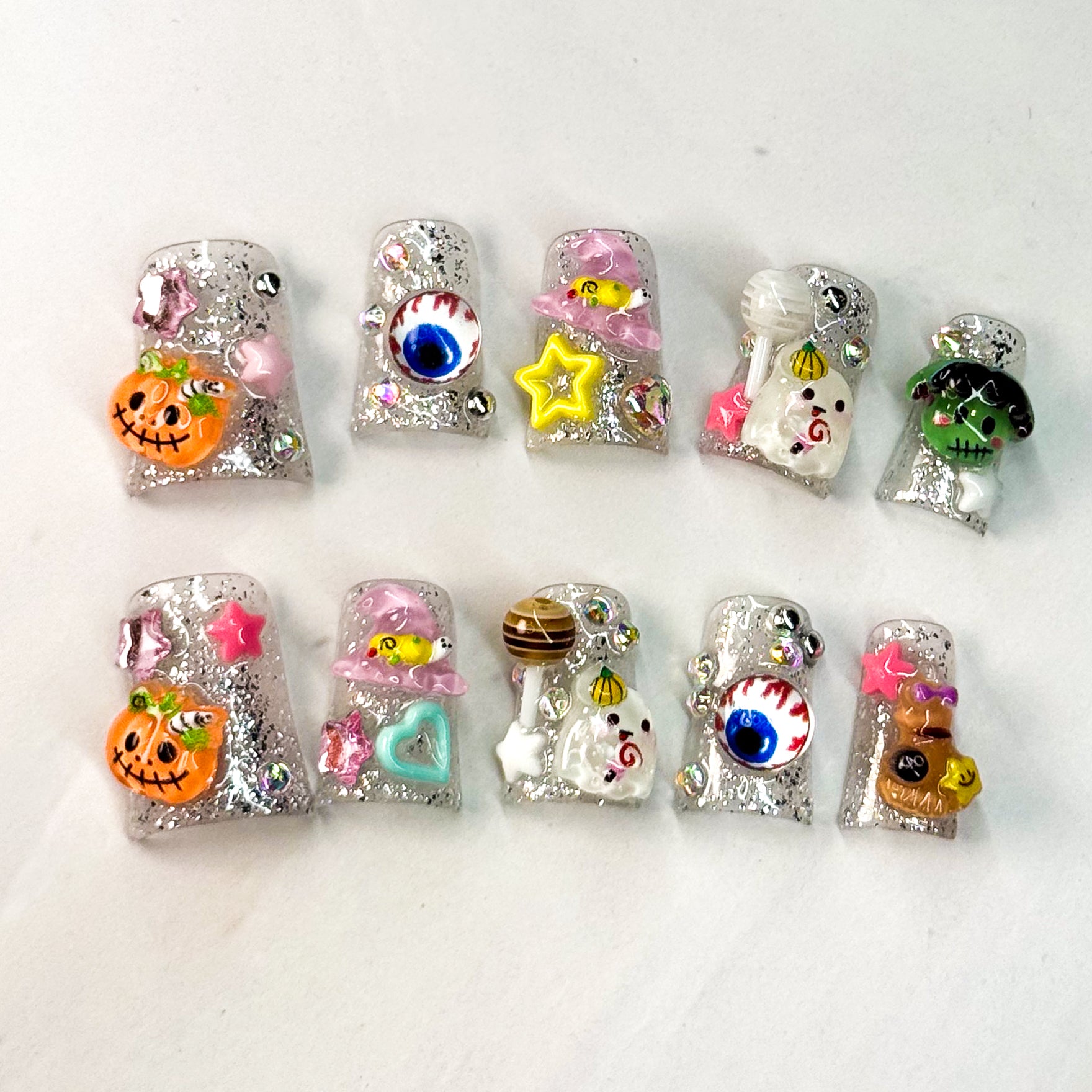 • Spooky-Sweet: Features pumpkins, ghosts, eyeballs, stars, and candies in 3D gel.
• Glitter Base: Sparkling silver with rhinestone accents for extra shine.
• Short Square Shape: Comfortable for daily wear while keeping the festive look.
• Halloween Fun: A colorful twist on classic spooky designs.
• Handmade & Reusable: Durable gel artistry that lasts.