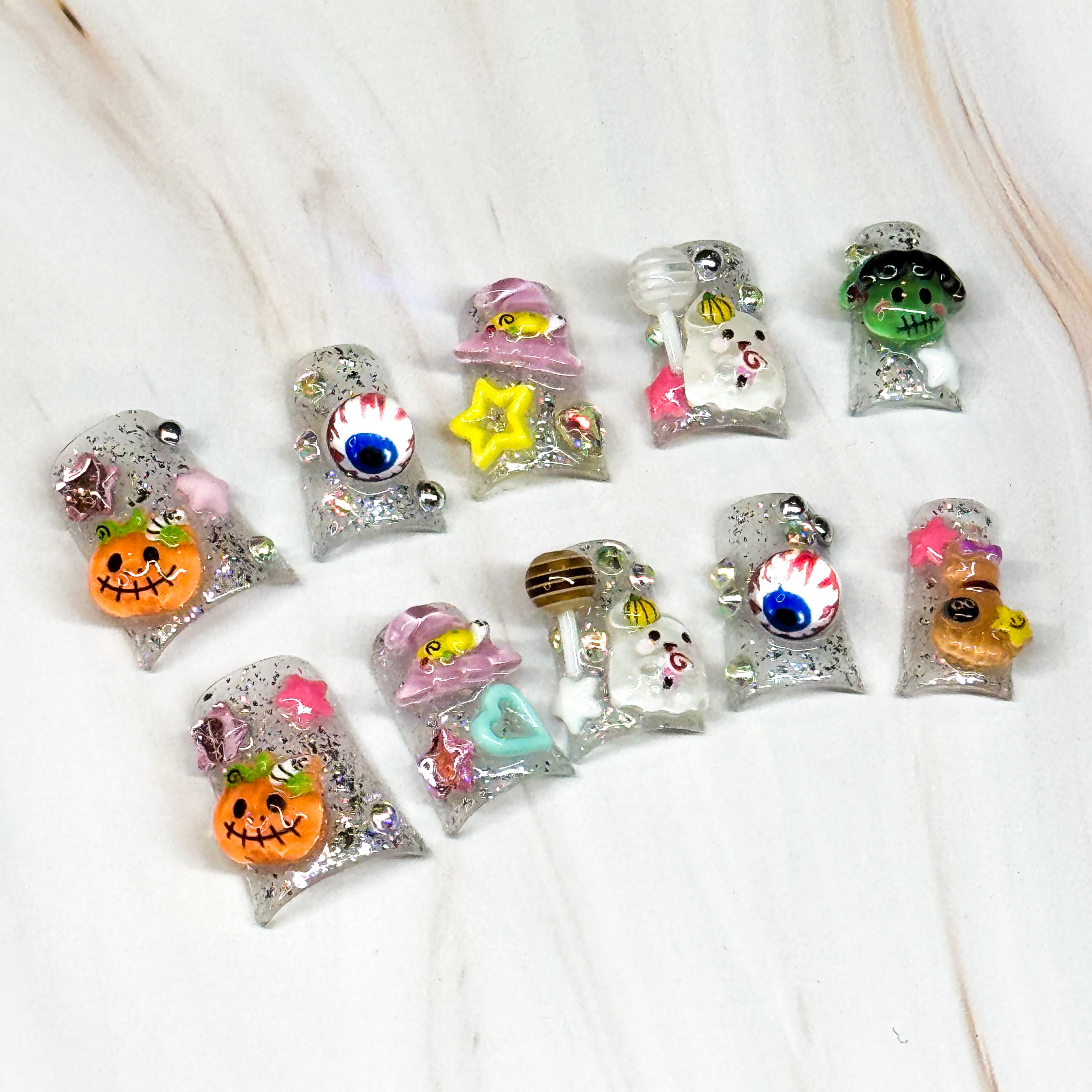 • Spooky-Sweet: Features pumpkins, ghosts, eyeballs, stars, and candies in 3D gel.
• Glitter Base: Sparkling silver with rhinestone accents for extra shine.
• Short Square Shape: Comfortable for daily wear while keeping the festive look.
• Halloween Fun: A colorful twist on classic spooky designs.
• Handmade & Reusable: Durable gel artistry that lasts.