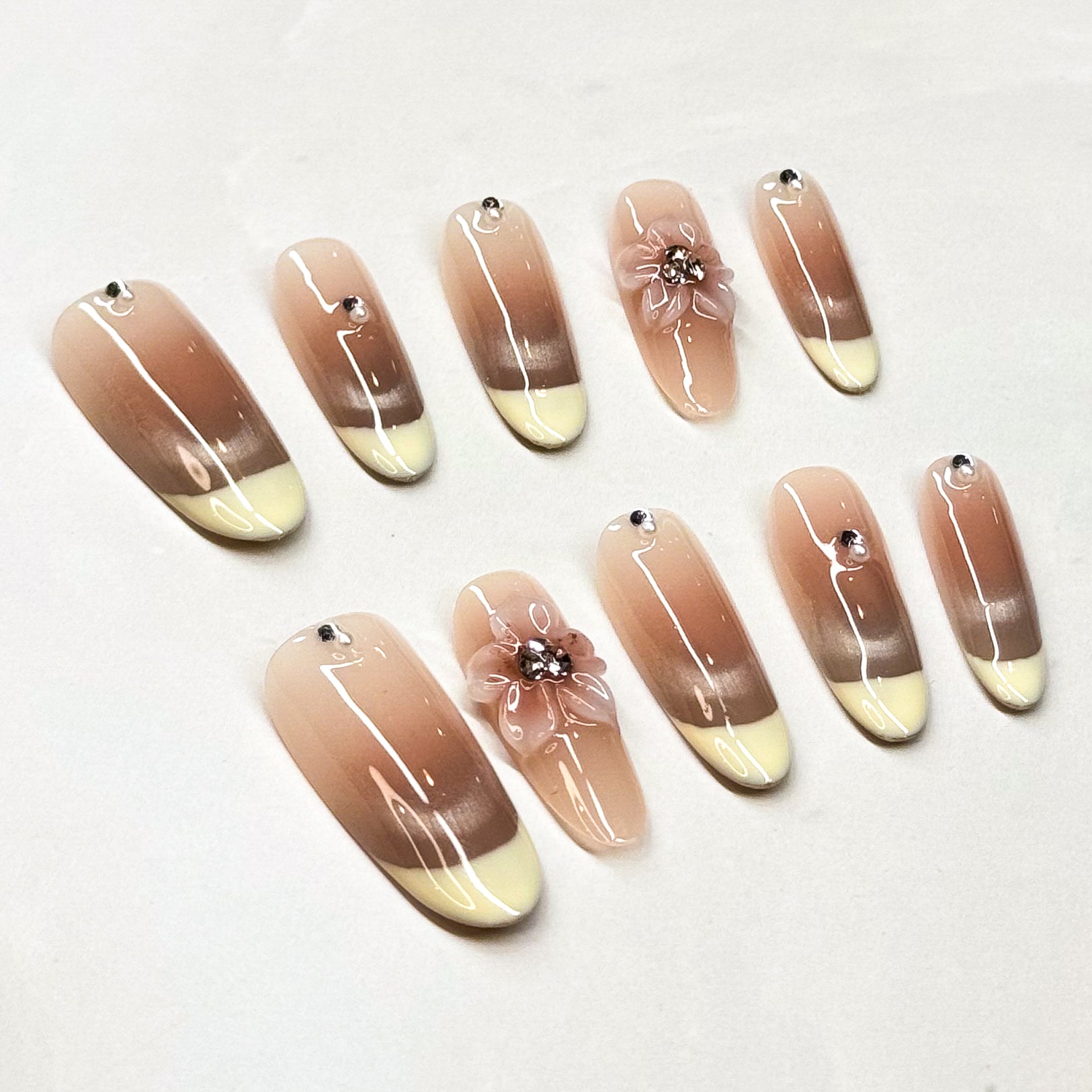 • Ombré Perfection: Smooth transition from warm nude to ivory tips.
• Crystal Glow: Subtle rhinestone accents for a touch of sparkle.
• 3D Floral Accent: Handcrafted flower detail for romantic charm.
• Long Shape: Sleek silhouette that elongates fingers.
• Handmade & Reusable: Salon-quality, durable, and customizable.