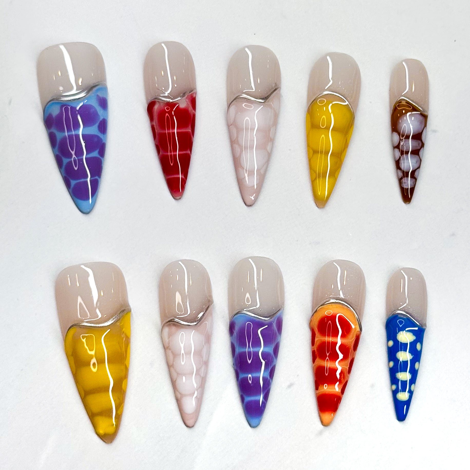 • Color Splash: Vibrant mix of purple, red, yellow, orange, blue, and more.

• Abstract Design: Translucent reptile-scale effect for a modern edge.

• Nude Contrast: Soft neutral base keeps the bold tones wearable.

• Long Stiletto/ Medium Almond Shape: Striking silhouette perfect for statement looks.

• Handmade &amp; Reusable: High-quality finish, built to last.