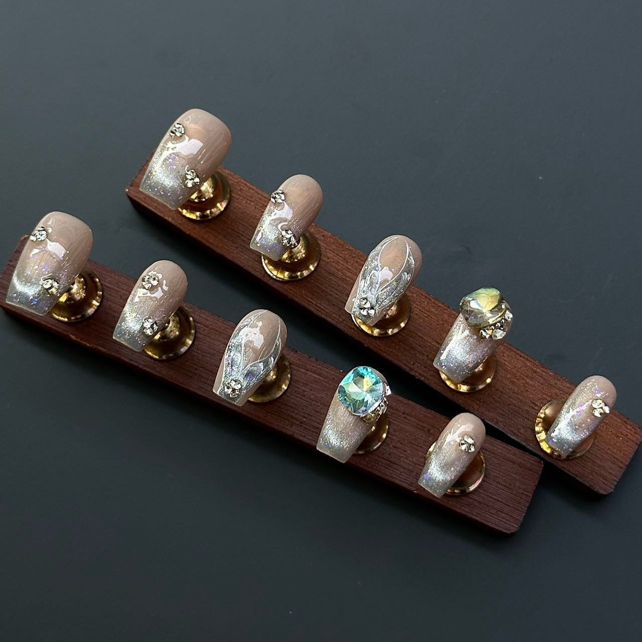 Embrace timeless elegance with the Opulent Aura Press-On Nails, a stunning blend of shimmering champagne hues and opalescent accents. Designed in a short coffin shape for sophisticated simplicity, this set features glittering cat-eye effects and intricate jewel embellishments, capturing the essence of refined luxury. The subtle nude base is beautifully enhanced with iridescent overlays and crystal accents, giving your nails a radiant, luminous glow.