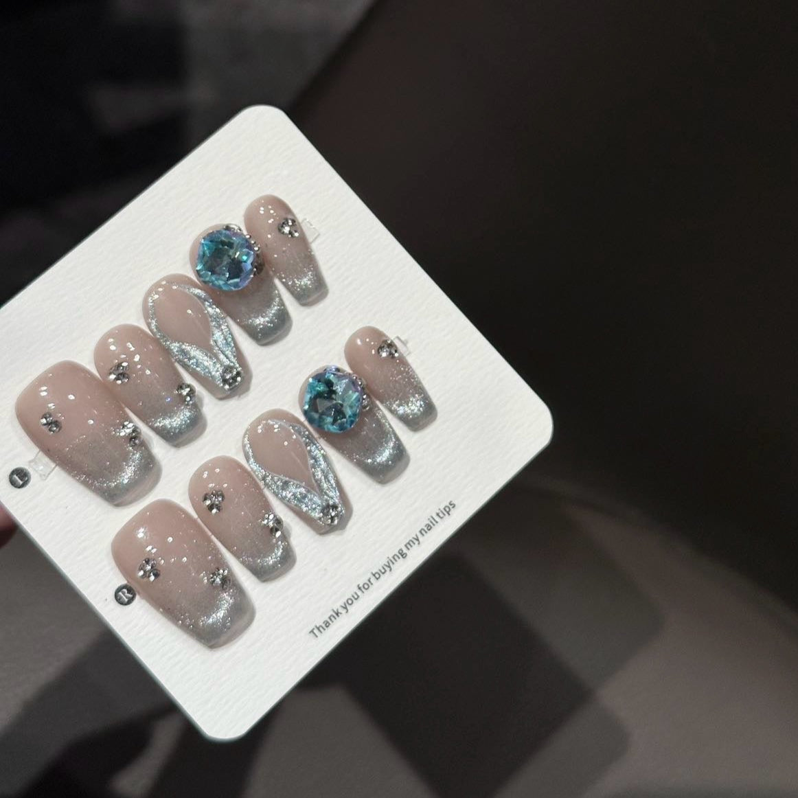 Embrace timeless elegance with the Opulent Aura Press-On Nails, a stunning blend of shimmering champagne hues and opalescent accents. Designed in a short coffin shape for sophisticated simplicity, this set features glittering cat-eye effects and intricate jewel embellishments, capturing the essence of refined luxury. The subtle nude base is beautifully enhanced with iridescent overlays and crystal accents, giving your nails a radiant, luminous glow.
