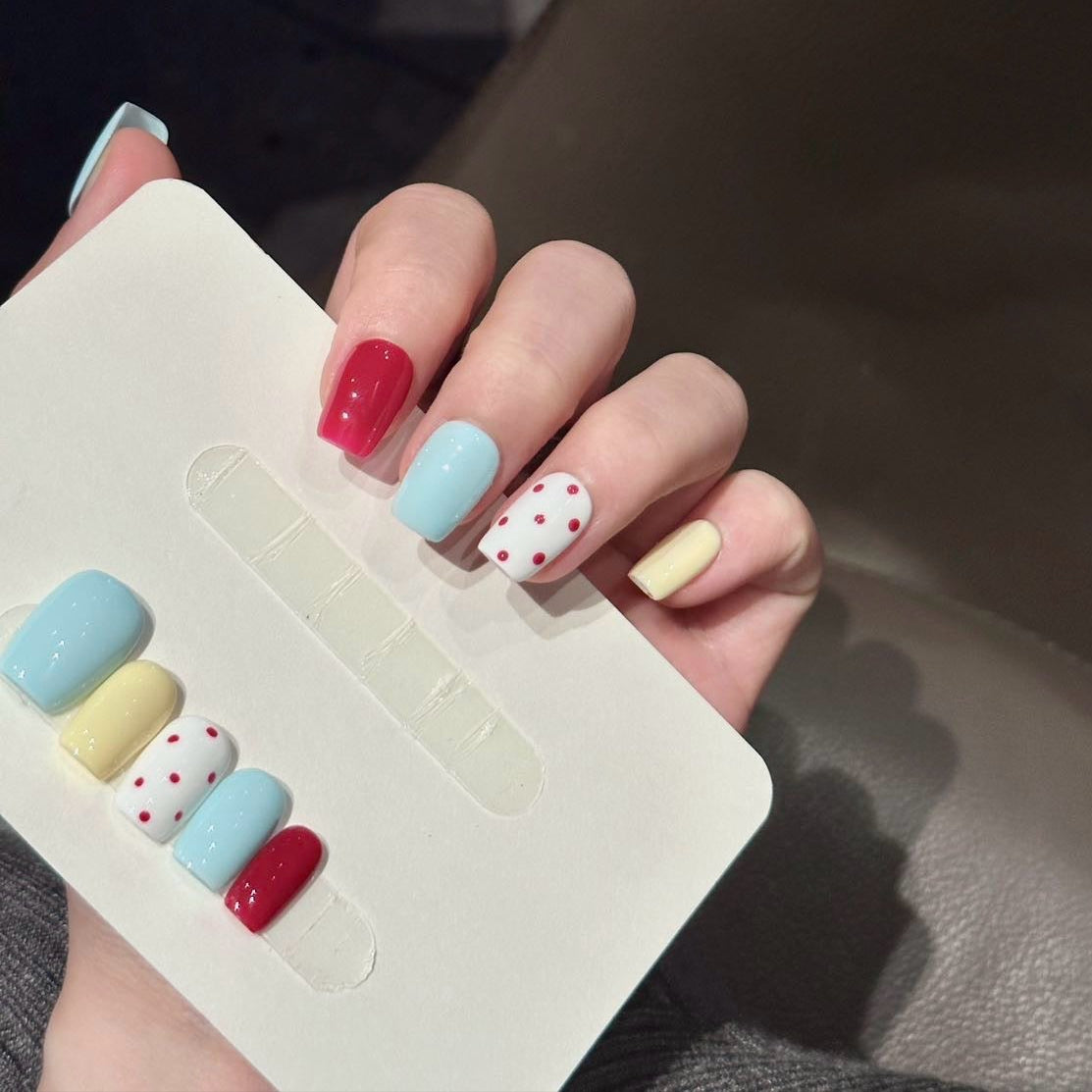 Add a playful touch to your style with Polka Dot Pop Press-On Nails, a vibrant mix of pastel blue, lemon yellow, cherry red, and playful red polka dots on white. This fun and whimsical set features a glossy finish and a cheerful color palette that exudes youthful energy and charm. With a structured short square shape, Polka Dot Pop brings a burst of retro-inspired fun to your fingertips.