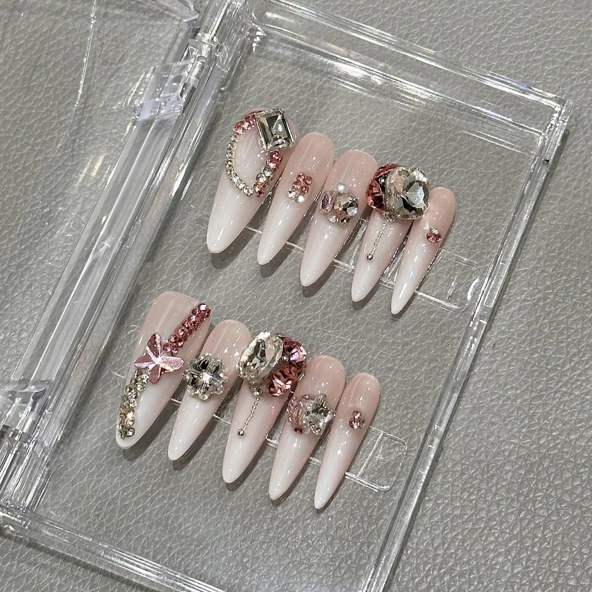 Step into opulence and grace with the Rose Empress Press-On Nails, a regal and exquisitely designed set that embodies luxury and sophistication. This romantic yet bold design features a soft pink-to-white ombré base adorned with crystal embellishments, rose-gold accents, and dazzling gemstone clusters.