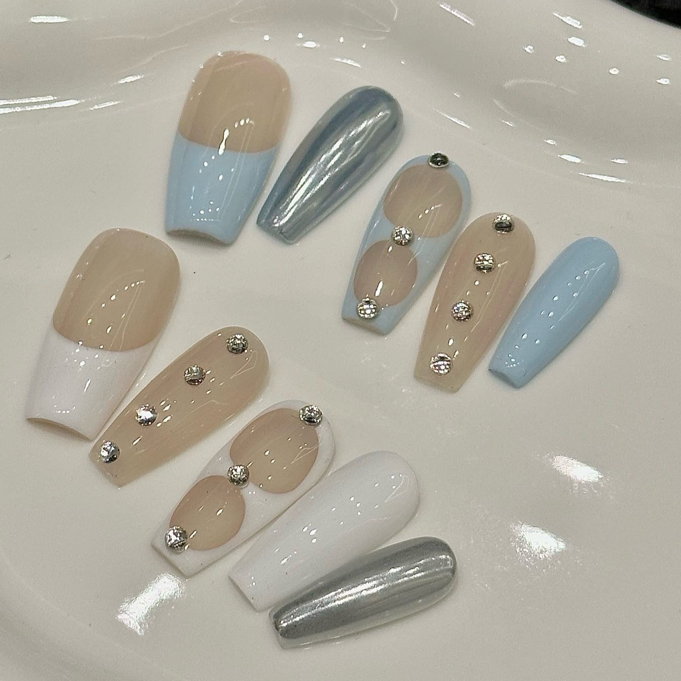 Serene Luxe Press-On Nails embody a perfect blend of minimalist sophistication and modern elegance. Featuring soft nude, baby blue, crisp white, and metallic silver accents, this set offers a dreamy, polished look for any occasion.