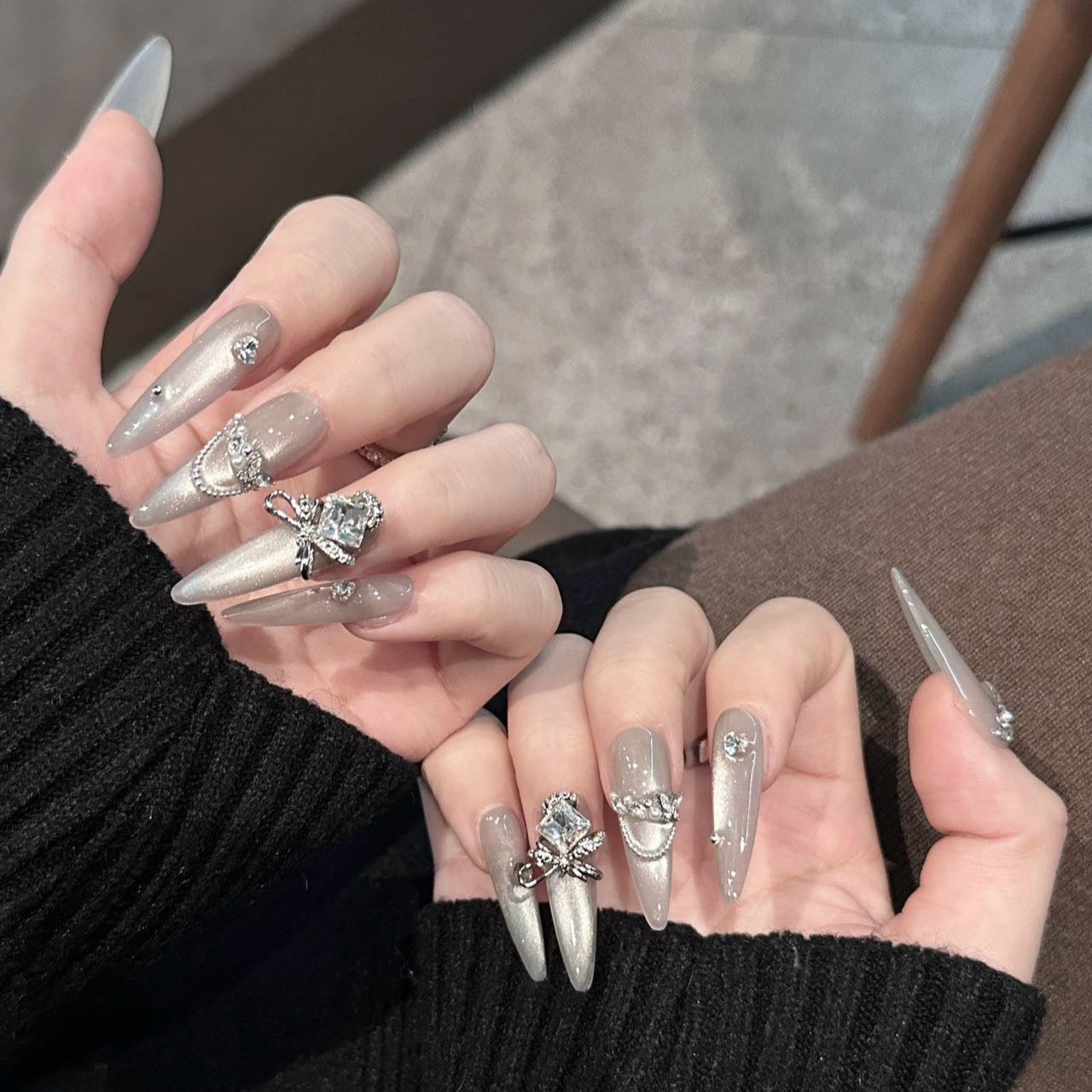 Embrace luxury and elegance with the Silver Luster Press-On Nails. This dazzling set combines shimmering silver tones, delicate rhinestone embellishments, and regal bow-shaped gems to create a sophisticated and glamorous look.