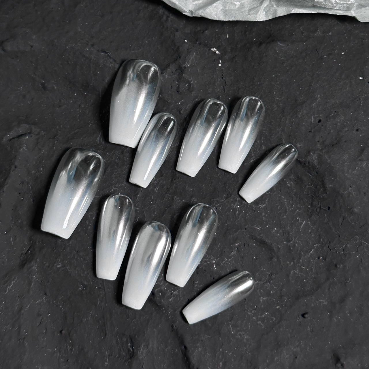 Silver Mist Press-On Nails are the epitome of modern elegance with a soft silver chrome finish that seamlessly blends into a translucent white base. These nails create a dreamy ombre effect that captures light beautifully, giving your hands a sophisticated, ethereal glow.
