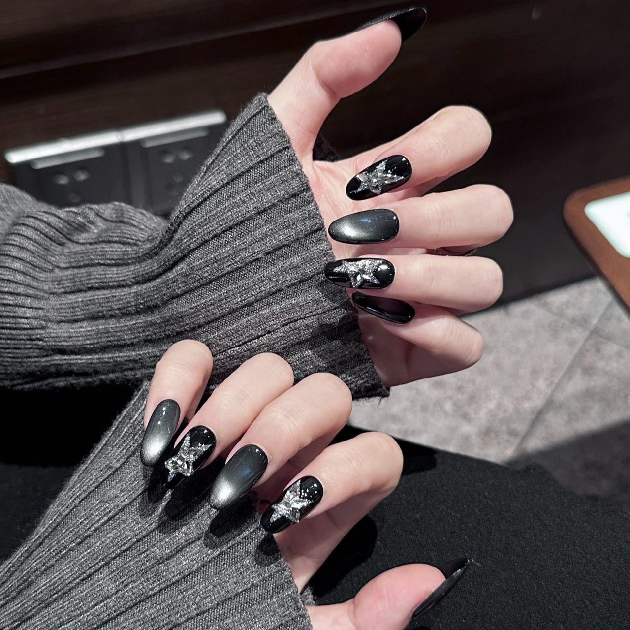 Starlit Shadows Press-On Nails capture the mystique of a starry night sky with a mesmerizing cat-eye effect that shimmers like cosmic dust. Accented with 3D silver star embellishments, these nails create a celestial and ethereal vibe that’s both elegant and edgy.