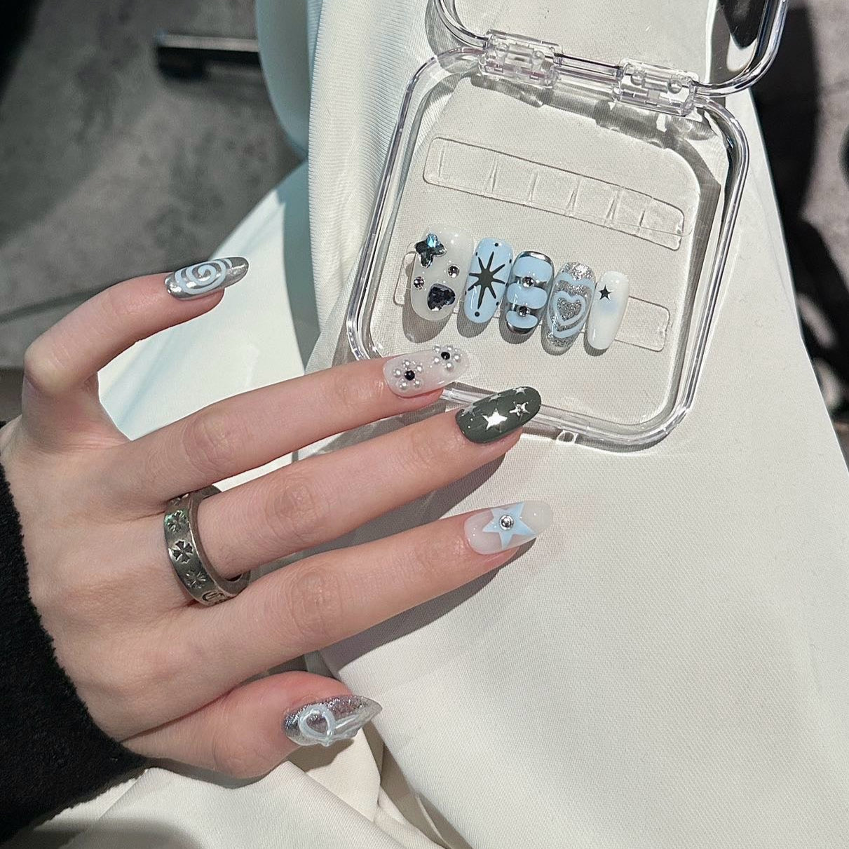 Stellar Twinkle Press-On Nails are a dreamy fusion of soft silver, icy blue, and celestial white, perfectly capturing the essence of a starlit sky. This set features a delightful mix of glittering star motifs, metallic accents, and whimsical swirl designs, bringing a magical and playful vibe to your fingertips.