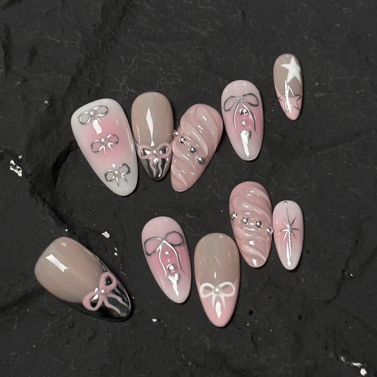 Embrace charming elegance with Whimsical Bows Press-On Nails, a delightful blend of soft blush pink, taupe, and delicate silver accents. This playful set features adorable bow designs, shimmering star motifs, and subtle rhinestone embellishments, capturing a whimsical, fairytale-inspired look. With a glossy finish and graceful almond shape, Whimsical Bows adds a touch of feminine sweetness to your style.
